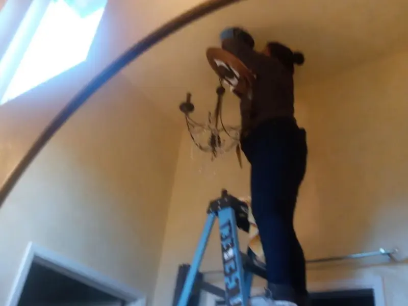 Electrician installing a chandelier in a Palmyra residence